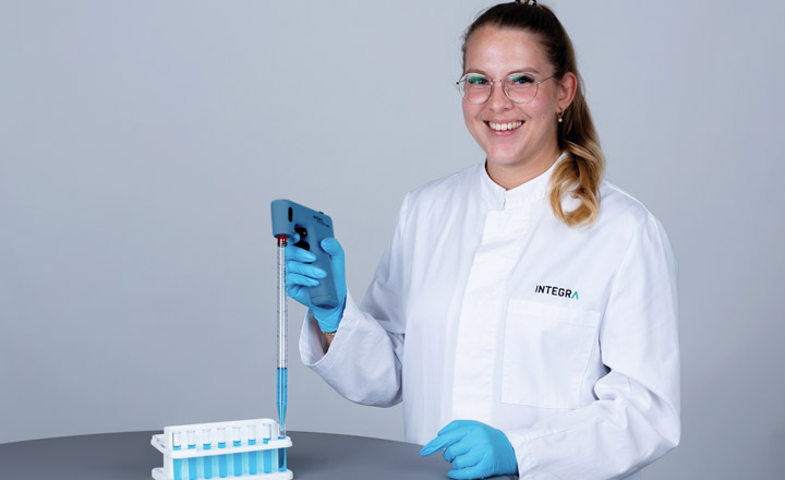 A scientist using a PIPETBOY GENIUS serological pipet controller