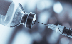 A syringe is used to remove a dose of a vaccine from a vial